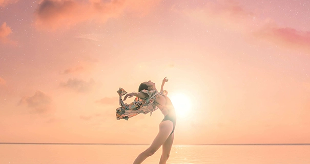 Femme qui s'éveille au dessus de l'eau devant un coucher de soleil