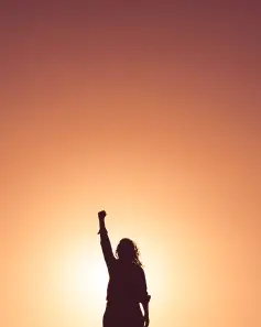 Femme qui met son point en l'air pour booster la confiance en soi